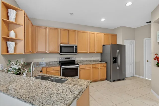 a kitchen with granite countertop a refrigerator and a sink