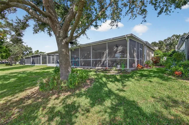 an aerial view of residential houses with outdoor space and trees