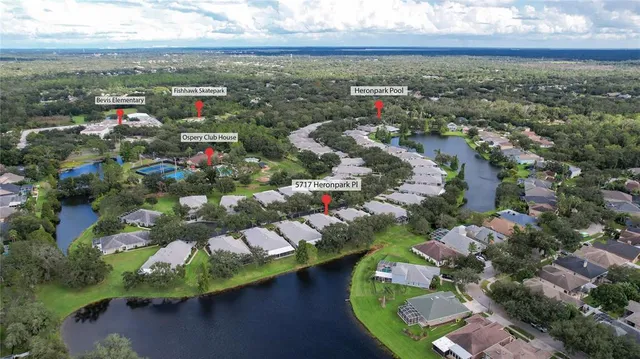 an aerial view of residential houses with outdoor space and lake view