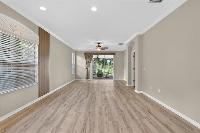 a view of an empty room with wooden floor