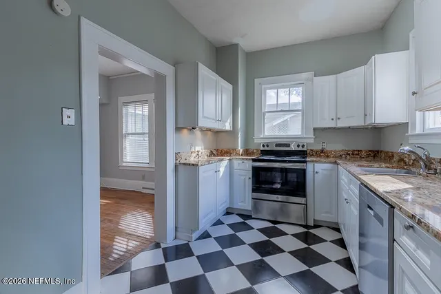 a kitchen with granite countertop stainless steel appliances a stove and a refrigerator