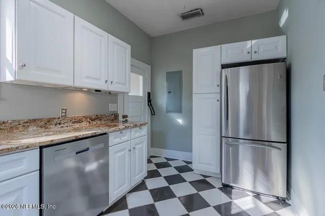 a kitchen with stainless steel appliances granite countertop a refrigerator and a stove top oven