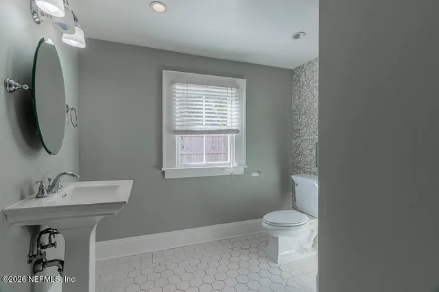 a bathroom with a toilet sink and mirror