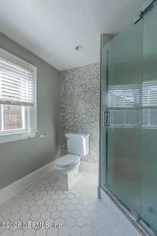 a bathroom with a toilet a sink and shower
