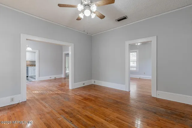 a view of an empty room with wooden floor