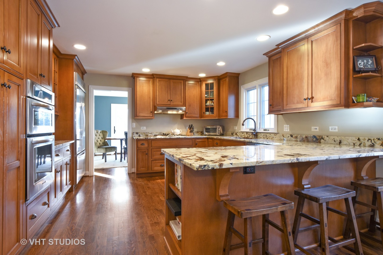 176 Old Sutton Road Barrington Hills, IL 60010 - Photo 2 of 27 a kitchen with stainless steel appliances granite countertop wooden floor a stove a sink and a refrigerator