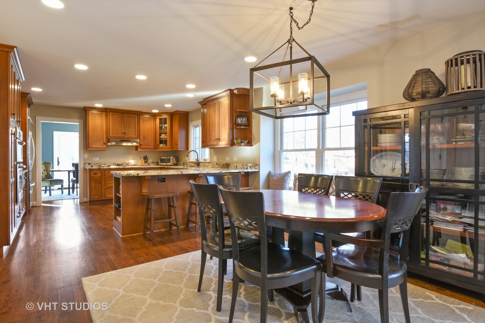 176 Old Sutton Road Barrington Hills, IL 60010 - Photo 6 of 27 a dining area with stainless steel appliances kitchen island granite countertop a dining table chairs and stove