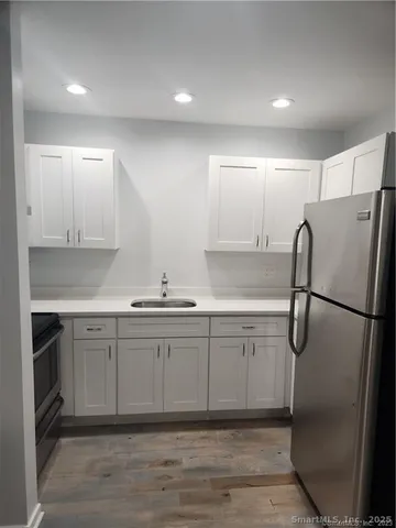 a kitchen with white cabinets and stainless steel appliances