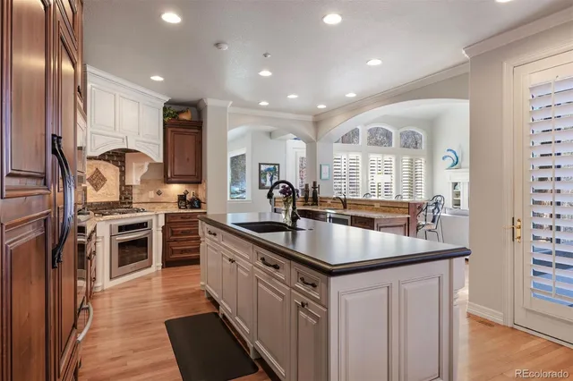 a kitchen with stainless steel appliances granite countertop a sink stove and refrigerator