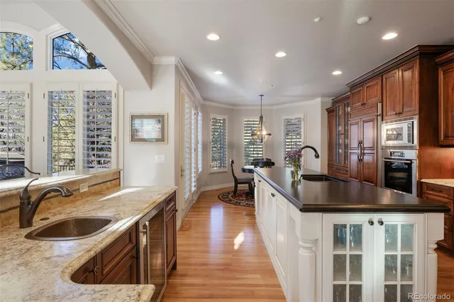 a kitchen with stainless steel appliances granite countertop a sink stove and wooden cabinets