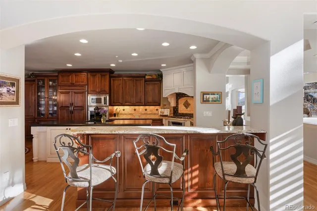 a kitchen with kitchen island granite countertop a stove and a sink