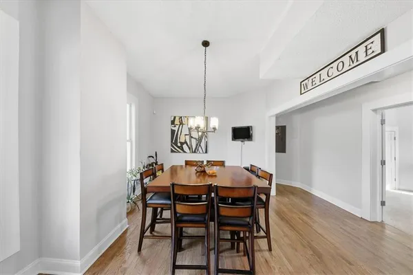 a kitchen with a refrigerator and wooden floor