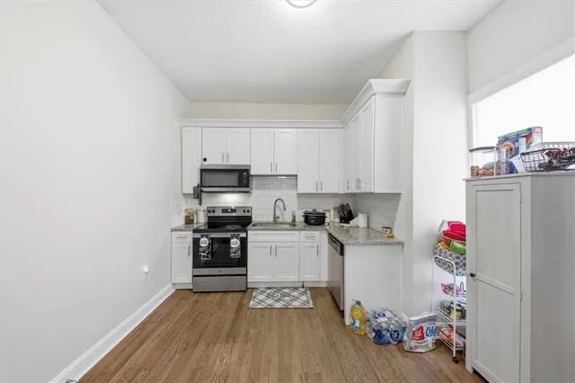 a kitchen with a refrigerator and white cabinets