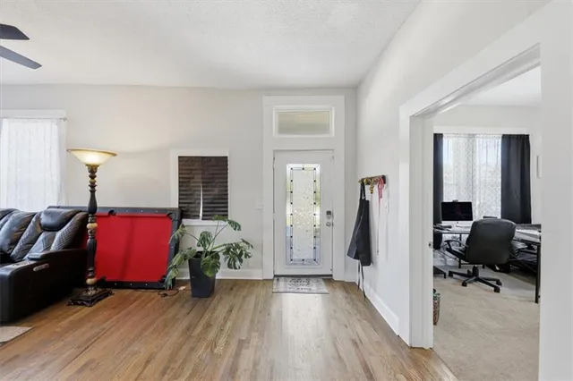 a view of an empty room with furniture and a window