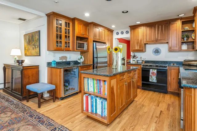 a kitchen with stainless steel appliances granite countertop a stove and a wooden cabinets