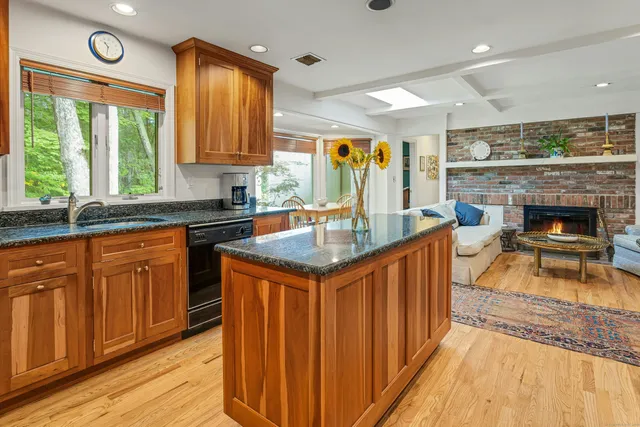 a kitchen with stainless steel appliances granite countertop a stove a sink dishwasher and cabinets with wooden floor