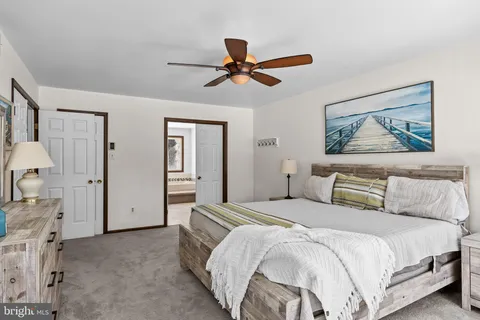 a bedroom with a large bed and a chandelier