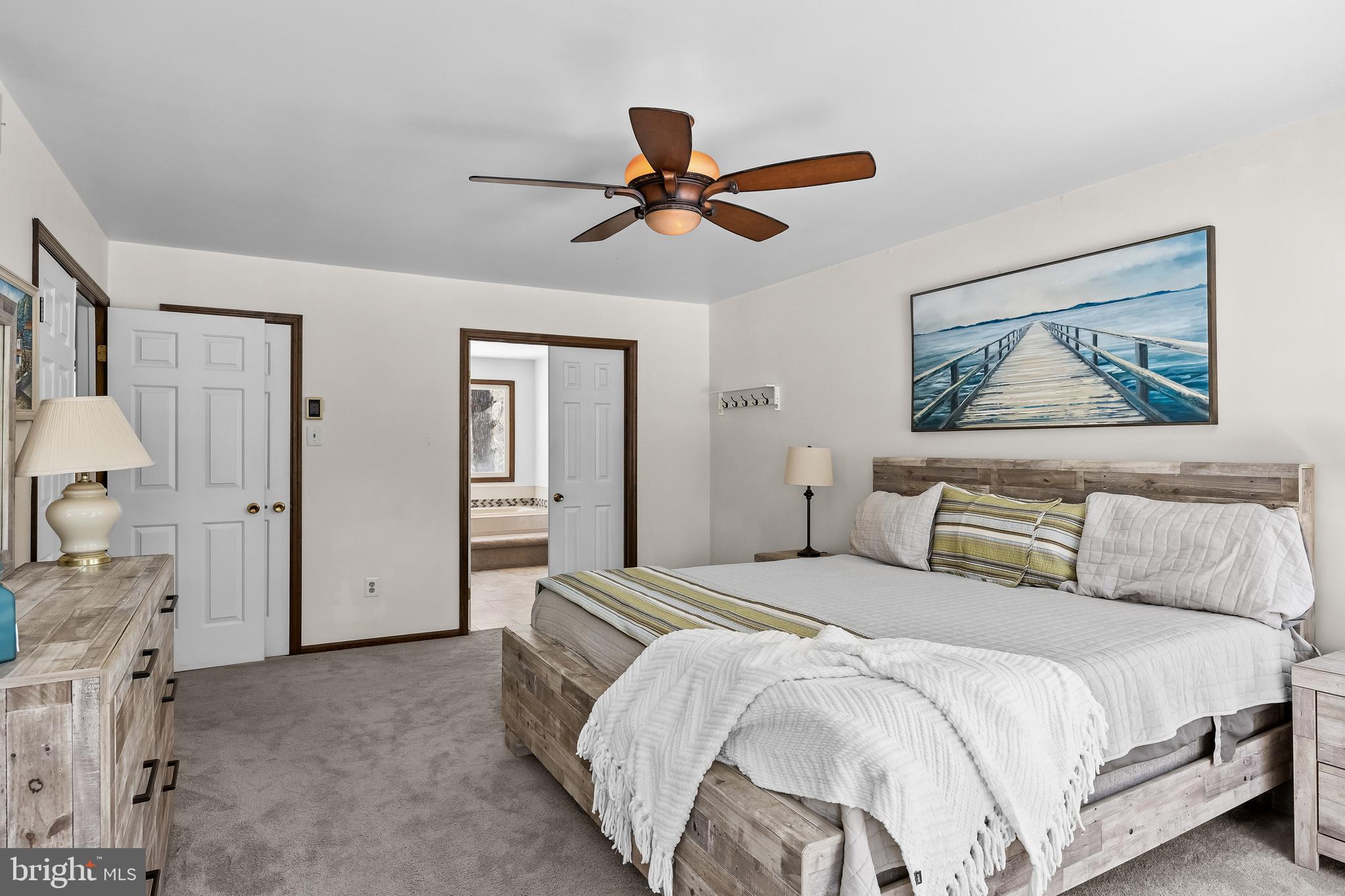 10 Lexington Court Shamong, NJ 08088 - Photo 19 of 47 a bedroom with a large bed and a chandelier