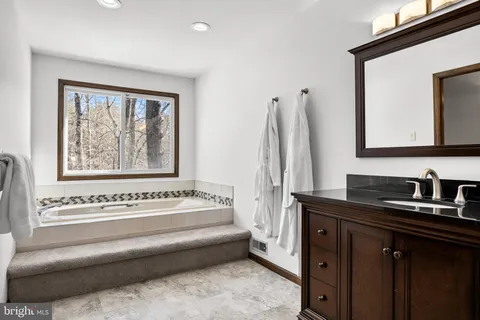 a bathroom with a bathtub sink and a mirror