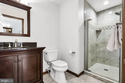 a bathroom with a granite countertop sink toilet and shower