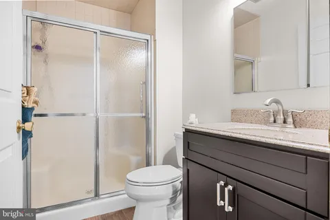 a bathroom with a granite countertop sink toilet and shower
