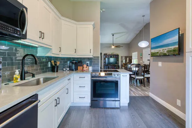 a kitchen with kitchen island granite countertop a sink cabinets and wooden floor
