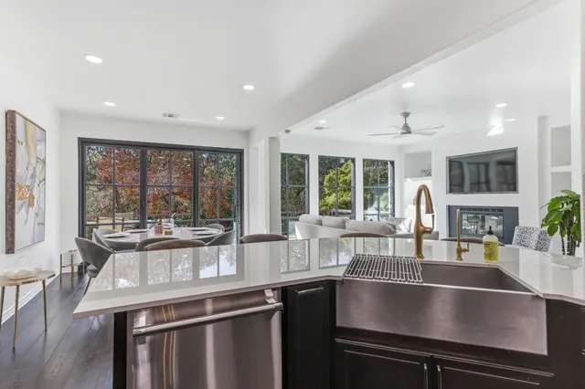 a open kitchen with stainless steel appliances granite countertop a sink and a large window