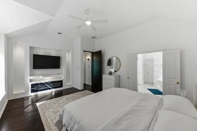 a bedroom with a bed and a flat tv screen on wall