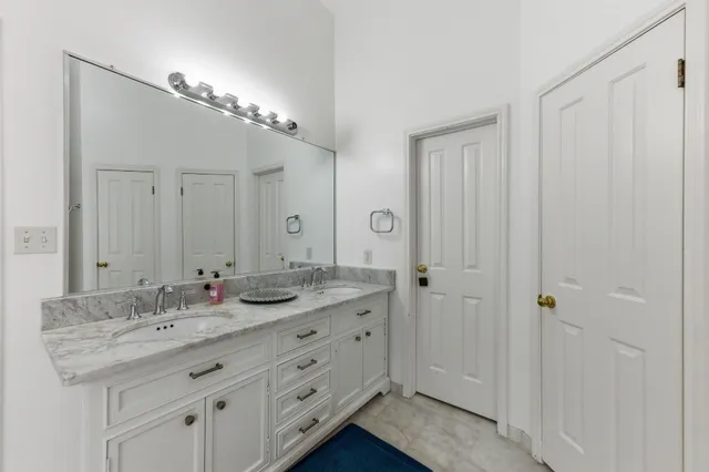 a bathroom with a granite countertop sink a mirror and a shower
