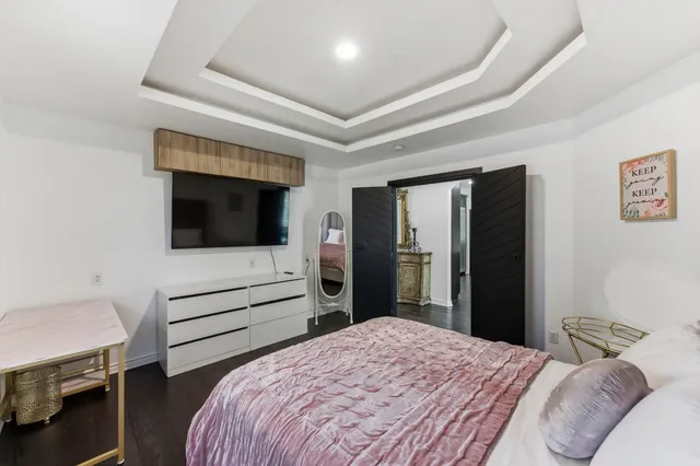 a bedroom with a bed and a flat screen tv