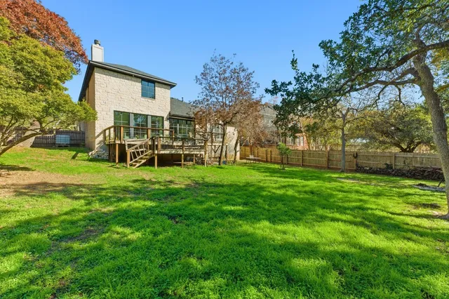 a view of a house with a big yard and large trees