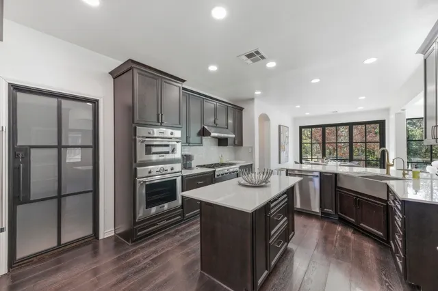 a kitchen with a sink stove top oven and refrigerator