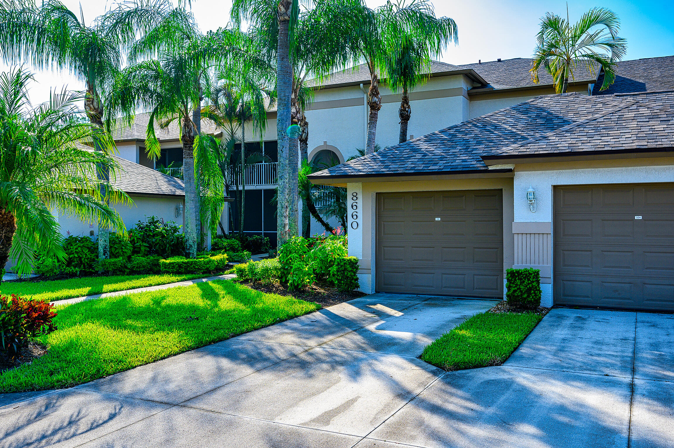 8660 Cedar Hammock Circle, Unit 314 Naples, FL 34112 - Photo 4 of 31 a front view of a house with a yard