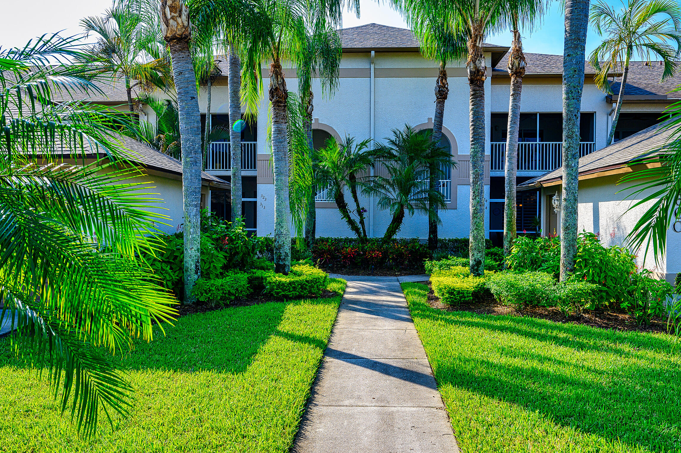 8660 Cedar Hammock Circle, Unit 314 Naples, FL 34112 - Photo 5 of 31 a front view of a house with a yard and potted plants