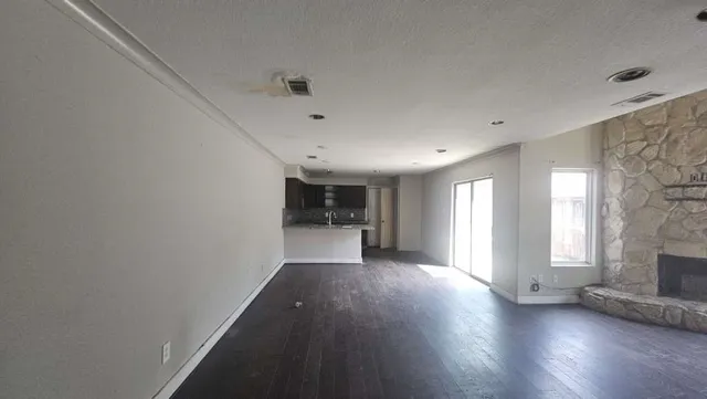 a view of a livingroom with wooden floor and a window