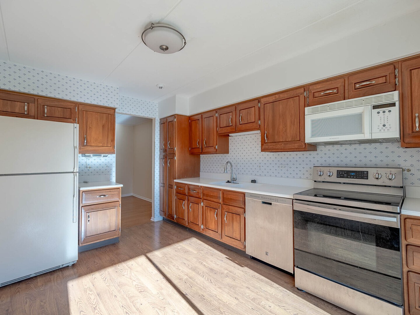 5818 Wolf Road, Unit 1A Western Springs, IL 60558 - Photo 6 of 14 a kitchen with stainless steel appliances granite countertop a refrigerator and a stove top oven