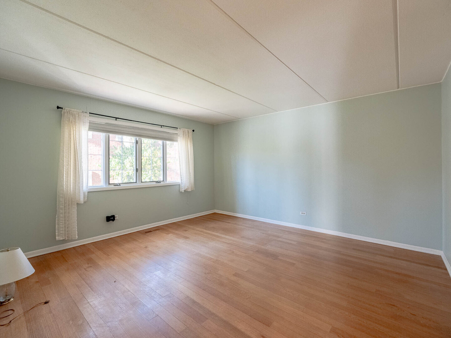 5818 Wolf Road, Unit 1A Western Springs, IL 60558 - Photo 10 of 14 a view of an empty room with wooden floor and a window
