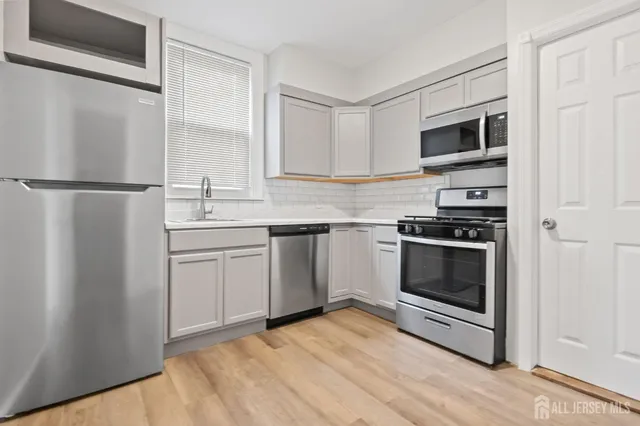 a kitchen with stainless steel appliances a refrigerator sink and microwave