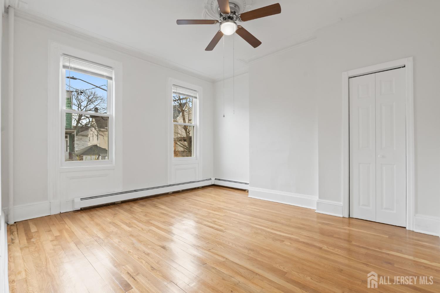 20 Linden Court, Unit 1 Jersey City, NJ 07305 - Photo 18 of 33 a view of an empty room with window and wooden floor