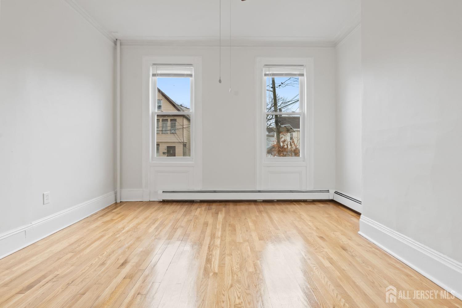 20 Linden Court, Unit 1 Jersey City, NJ 07305 - Photo 19 of 33 an empty room with wooden floor and windows