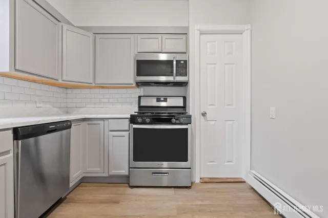 a kitchen with stainless steel appliances a refrigerator stove and microwave