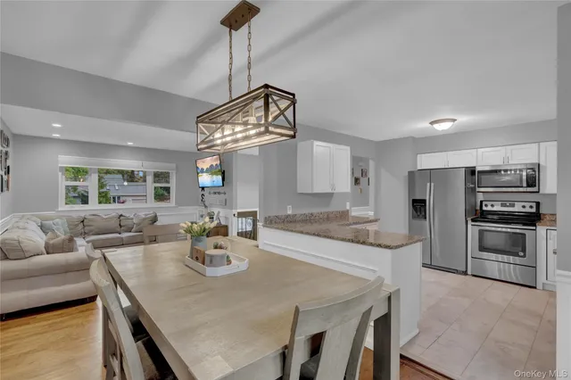 a kitchen with stainless steel appliances granite countertop a sink a stove and chairs