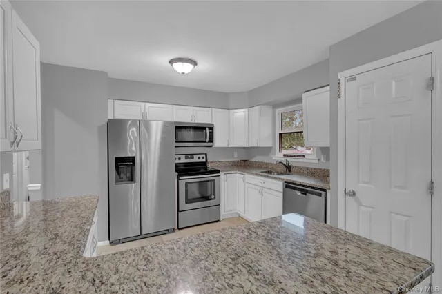 a kitchen with stainless steel appliances granite countertop a refrigerator sink and stove