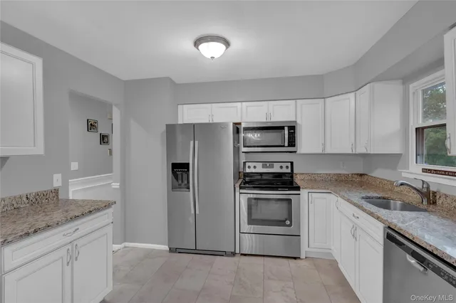 a kitchen with stainless steel appliances granite countertop a refrigerator stove and sink