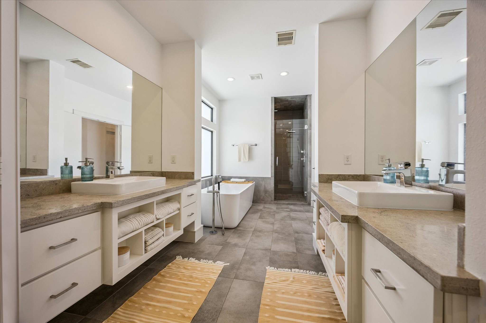 1810 Ridgewood Street Houston, TX 77006 - Photo 17 of 30 The well-appointed PRIMARY BATH features separate vanity areas with engineered quartz surfaces, wall-to-wall mirrors, and a walk-in shower.