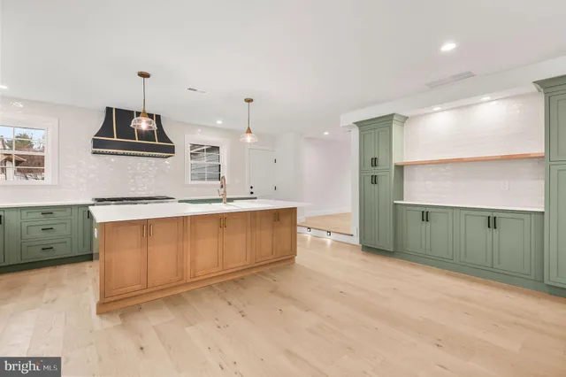 a kitchen with stainless steel appliances granite countertop a sink a stove a refrigerator and cabinets