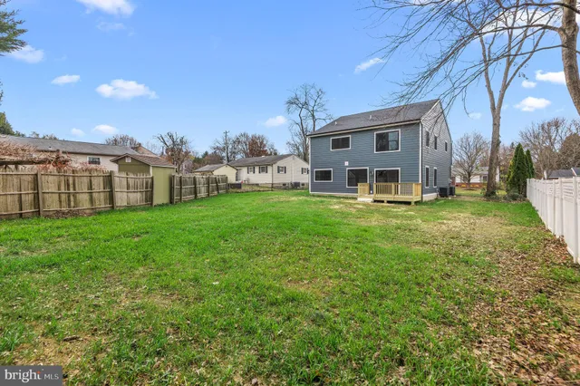 a view of a house with a big yard and large trees