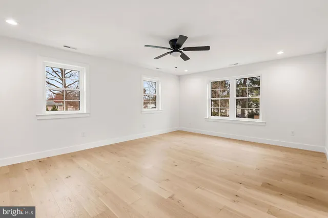 a view of an empty room with a window and wooden floor