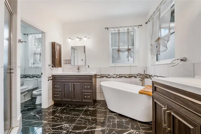 a bathroom with a tub sink and mirror