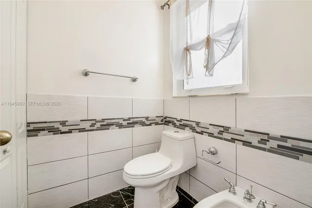 a bathroom with a granite countertop toilet sink and mirror